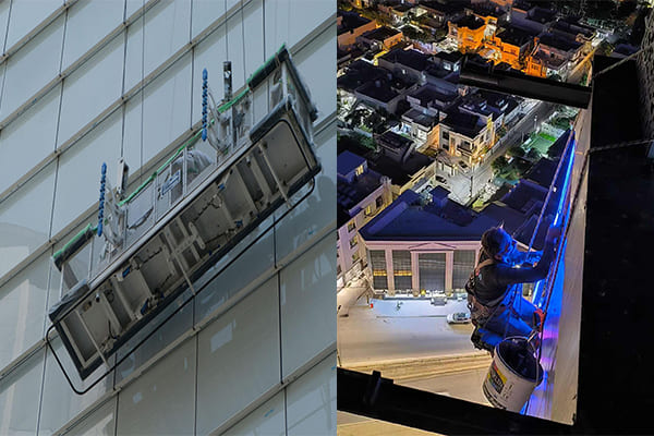 Installation crew working on a building facade with lifts